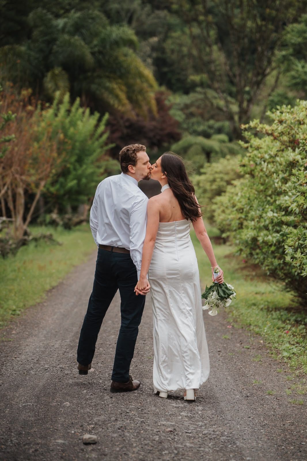 Letícia e Pablo de costas, de mãos dadas, se beijando na estrada de terra